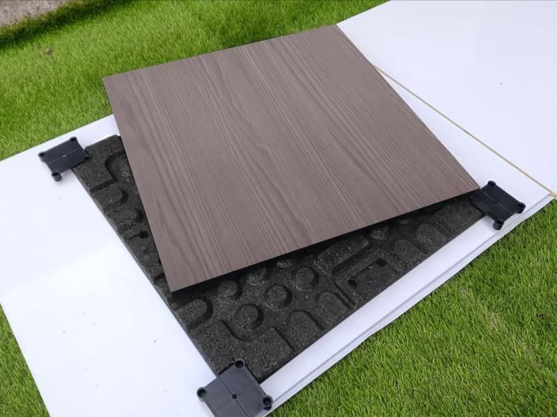 Szczegółowy schemat przedstawiający przekrój gumowej podłogi do siłowni na betonowym podłożu, ilustrujący rozkład siły uderzenia.